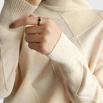 Ivory turtleneck sweater with ribbed knit cuffs and large diamond panel