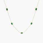 Gold chain necklace with evenly spaced green rectangular stones on a long chain.