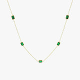 Gold chain necklace with evenly spaced green rectangular stones on a long chain.
