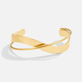 Gold open cuff bracelet with curved bar design and slim hinged band.