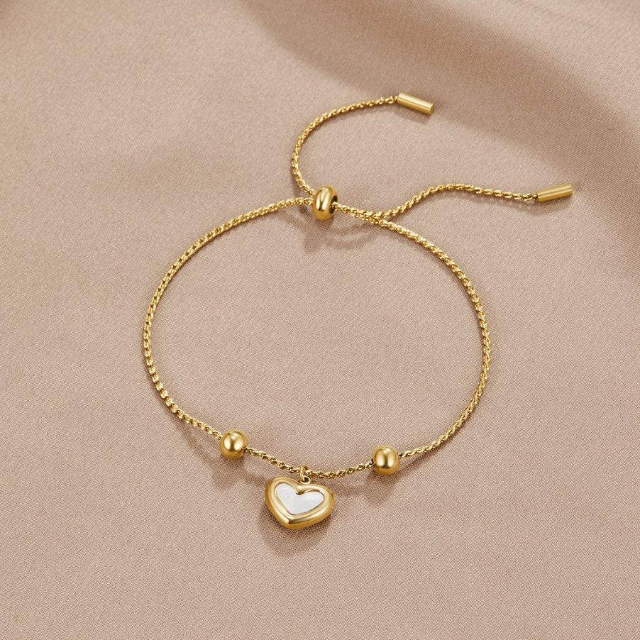 Gold heart charm bracelet with adjustable bar ends and heart pendant.