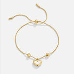 Gold heart charm chain bracelet with toggle bar and bead accents.