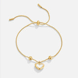 Gold heart charm chain bracelet with toggle bar and bead accents.