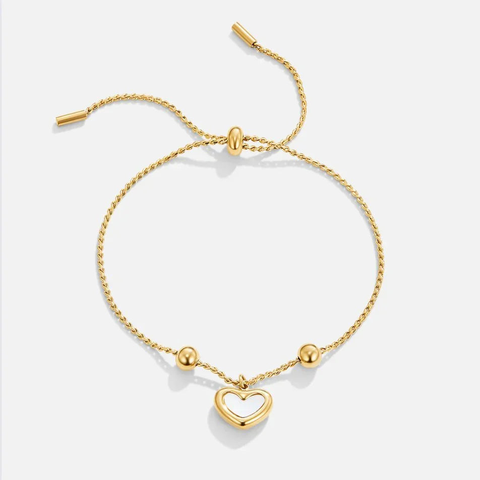 Gold heart charm chain bracelet with toggle bar and bead accents.
