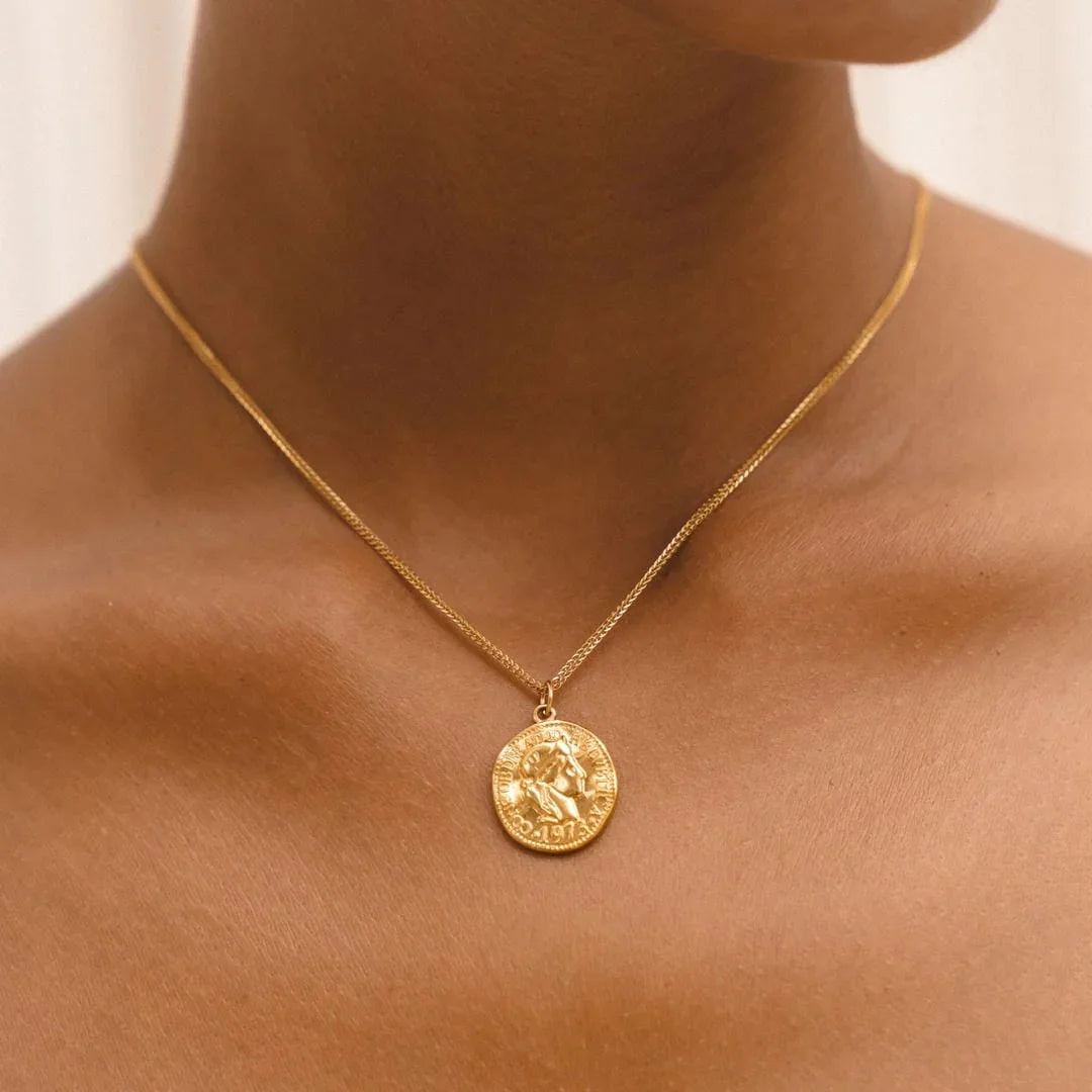 Gold coin pendant necklace with round antique-style medallion on thin chain