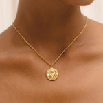Gold coin pendant necklace with round antique-style medallion on thin chain