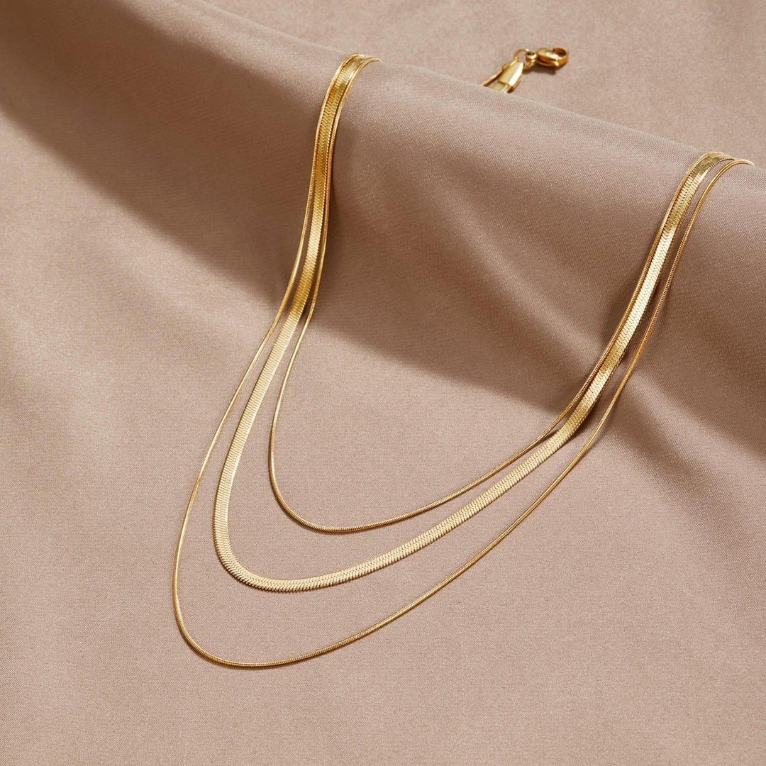 Gold multi-layer necklace with three slender chain loops and clasp at top