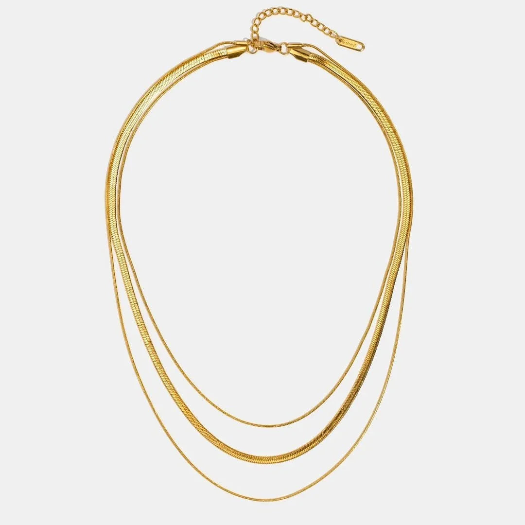 Gold multi-layer necklace featuring stacked oval chains with small bead toggle clasp
