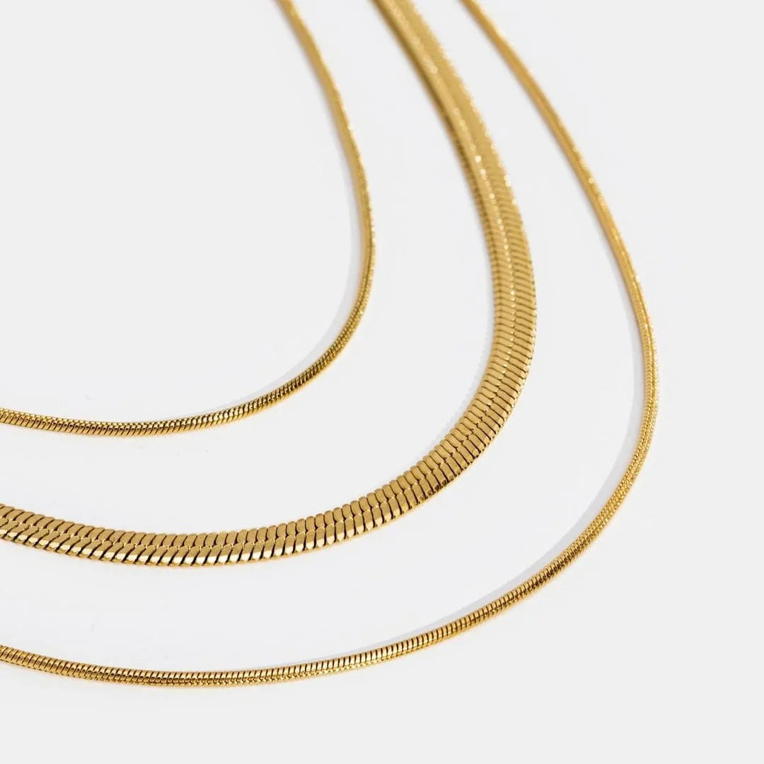 Gold multi-layer necklace close-up of textured chain links in layered curves