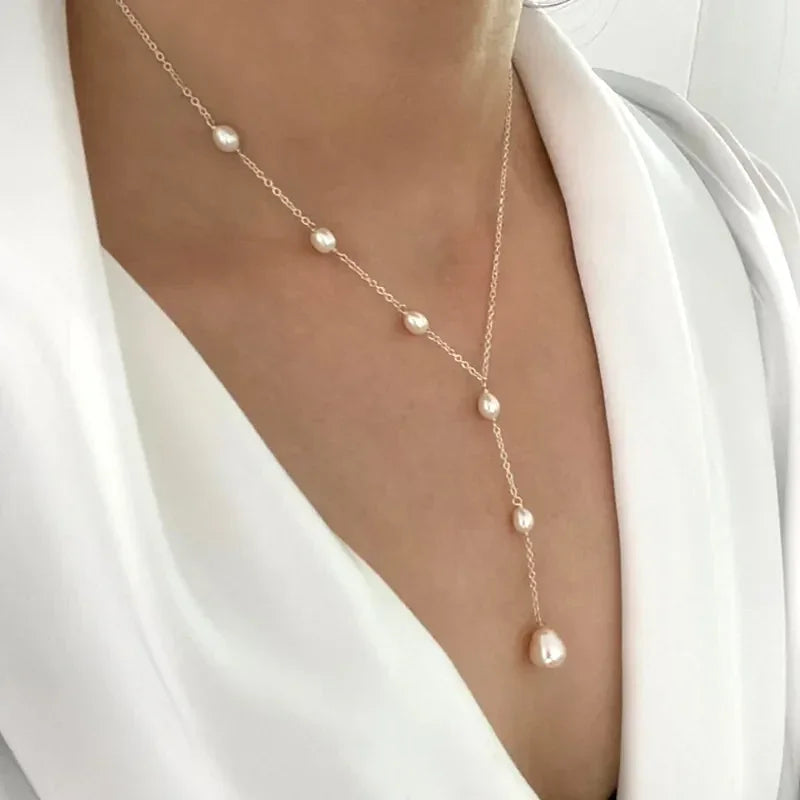 Gold-tone pearl chain necklace with evenly spaced pearls and teardrop end