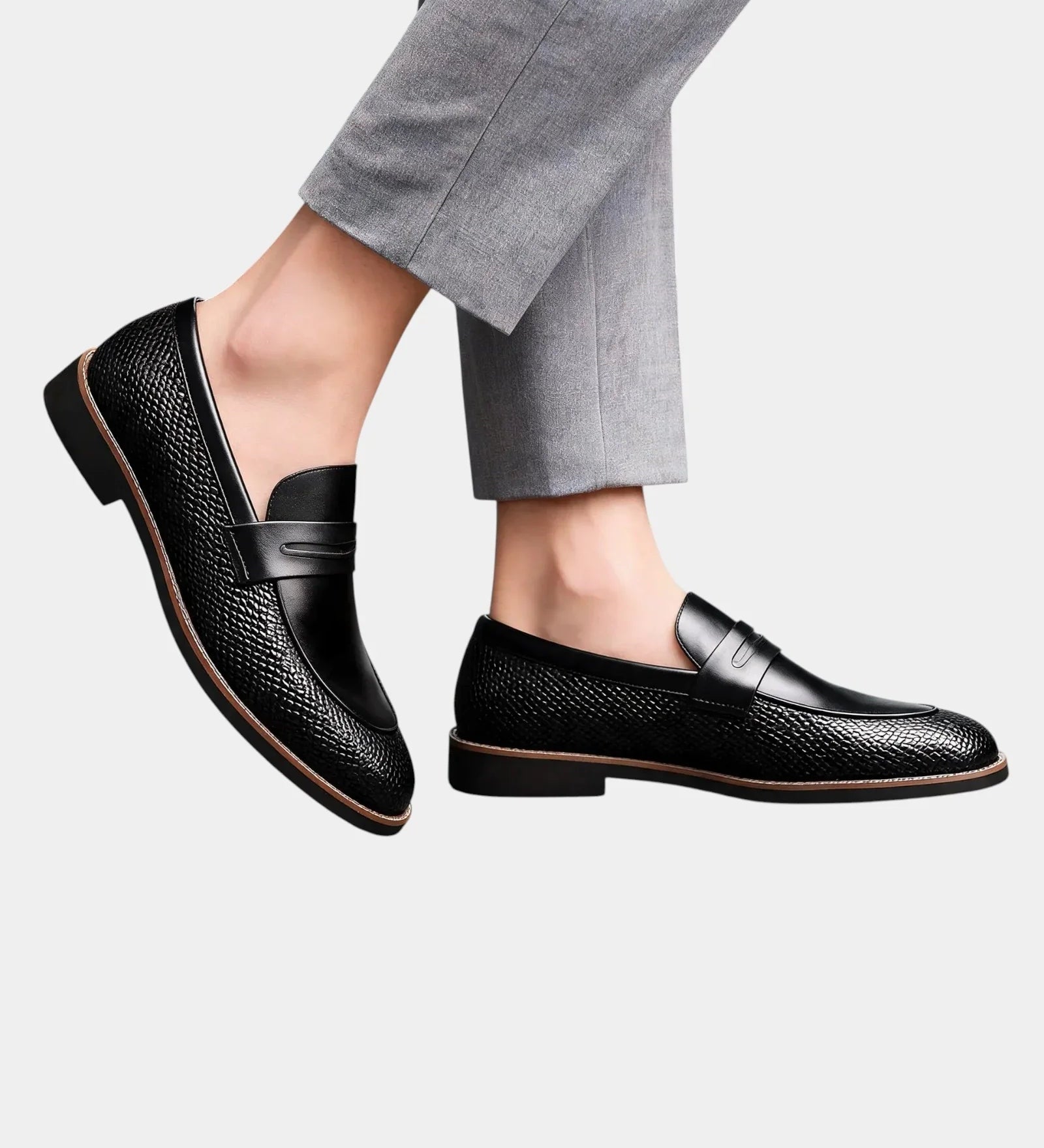 Classic black leather loafers with strap detail and textured upper, worn with cropped pants