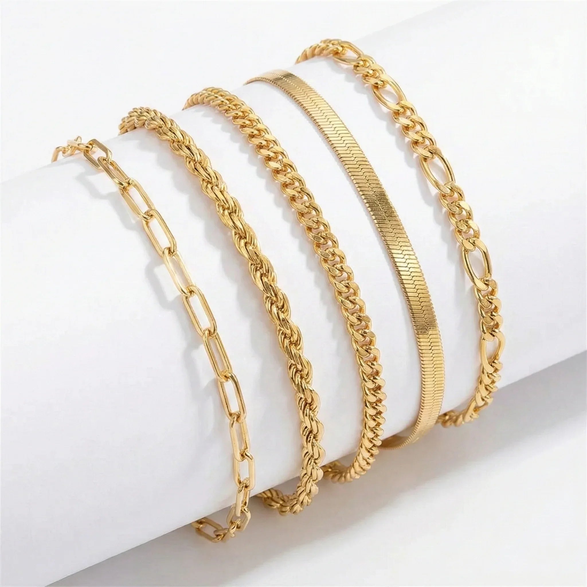 Gold bracelet set with multiple chain styles and clasp links, layered on wrist display