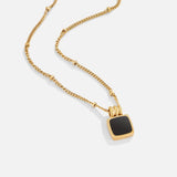 Gold chain pendant necklace featuring a black square centerpiece with bail