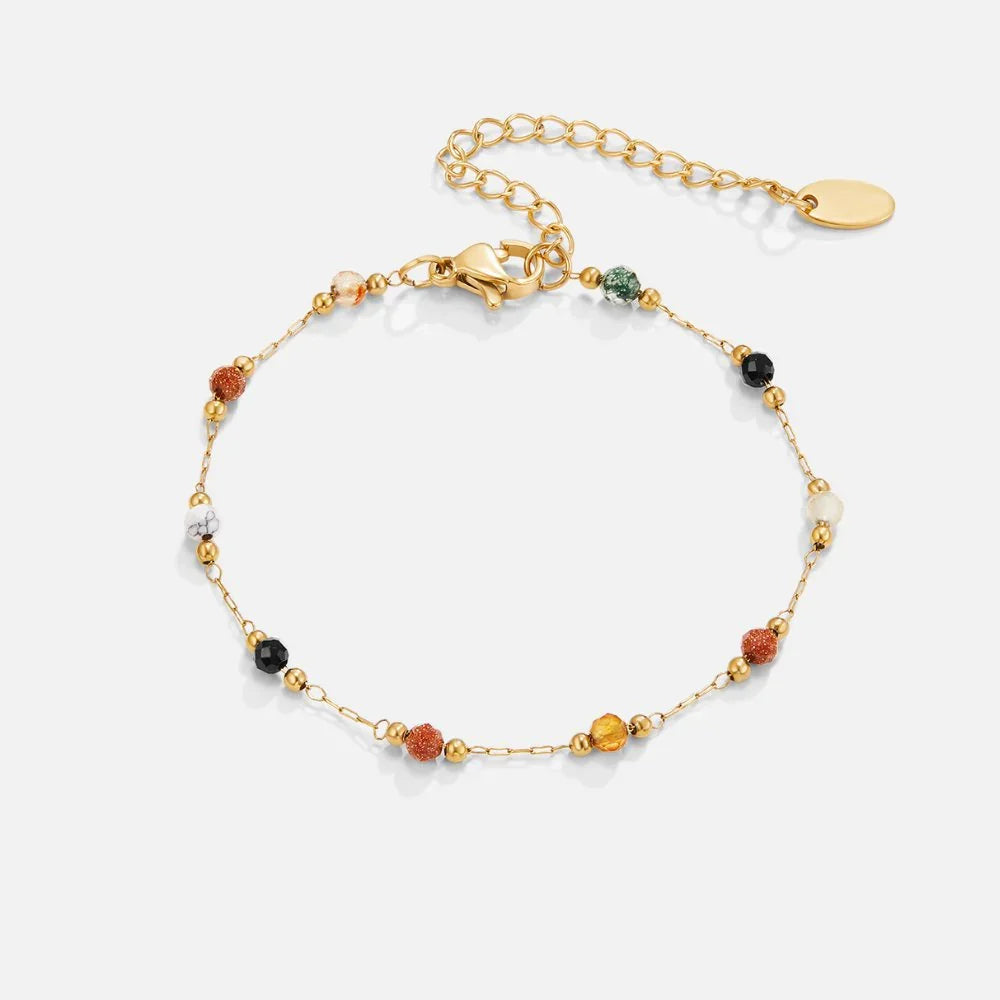 Gold beaded bracelet with assorted stone beads and oval tag clasp