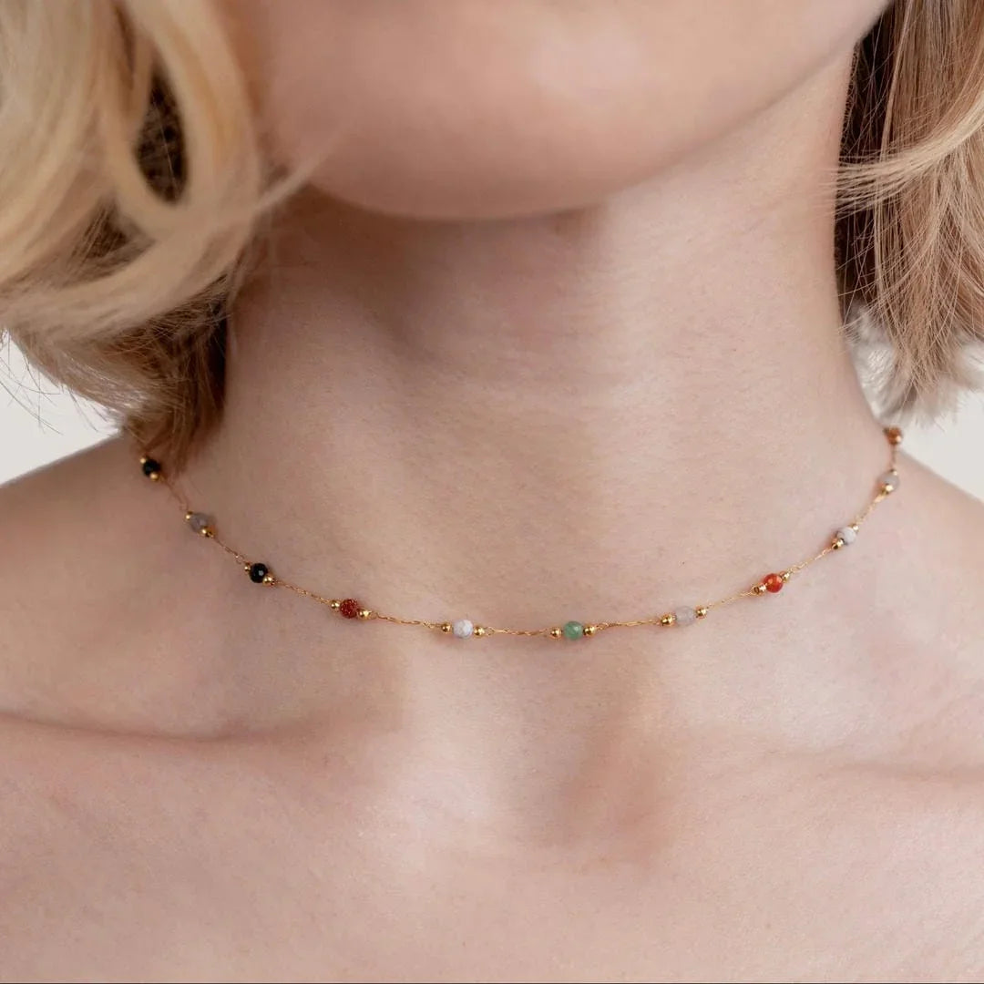 Gold gem necklace with multicolor bead stones, close view on collar