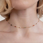 Gold gem necklace with multicolor bead stones, close view on collar