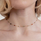Gold gem necklace with multicolor bead stones, close view on collar