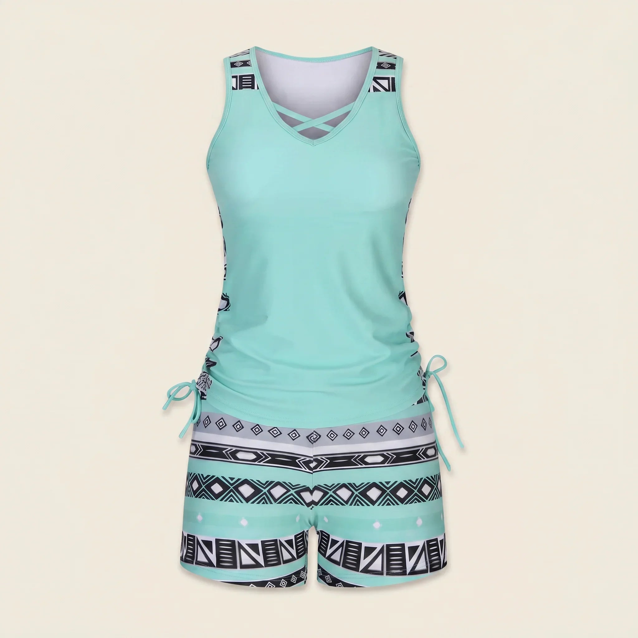 Teal tankini set with crisscross V-neck and black-and-white geometric drawstring shorts