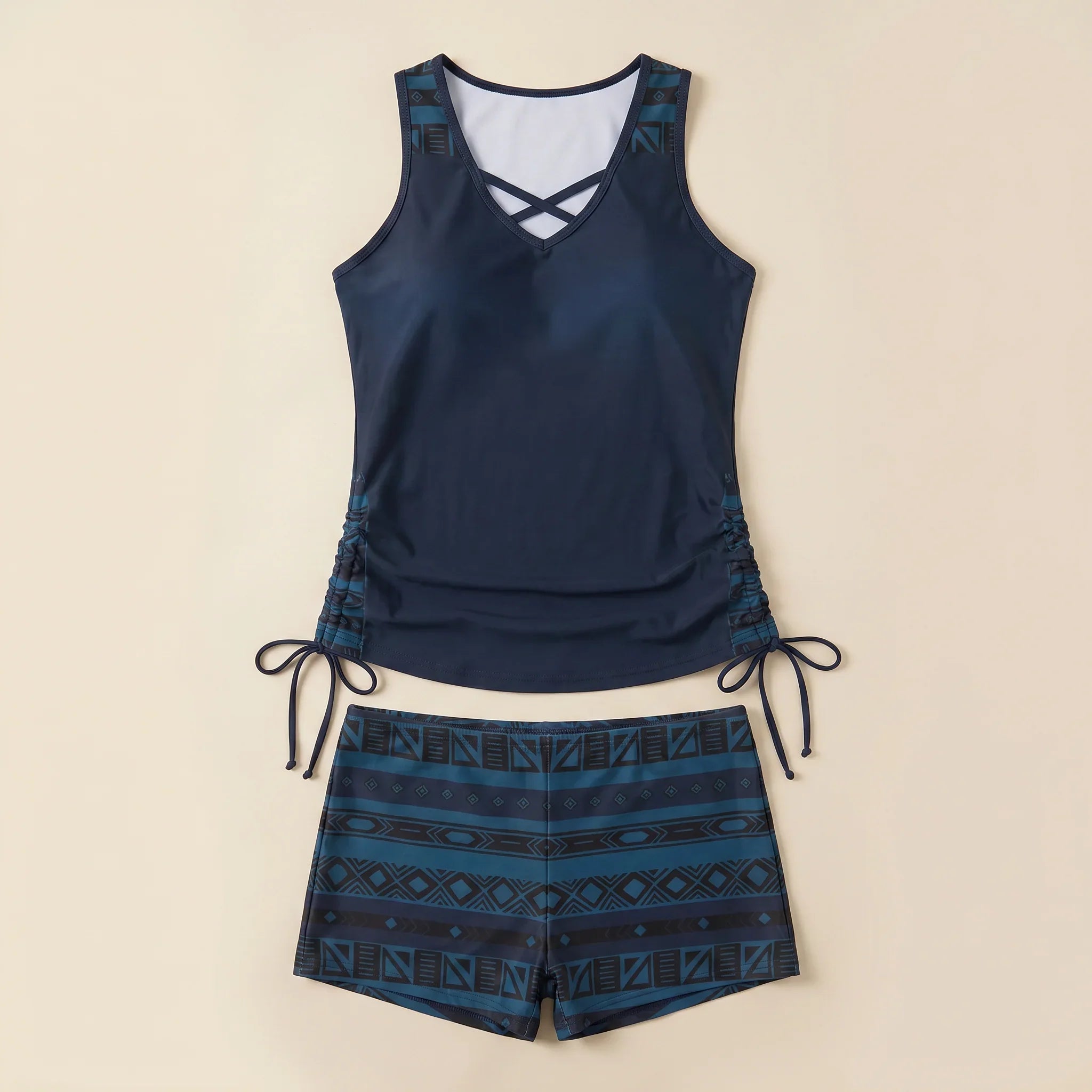 Navy tankini set with crisscross V-neck and navy-and-teal geometric drawstring shorts