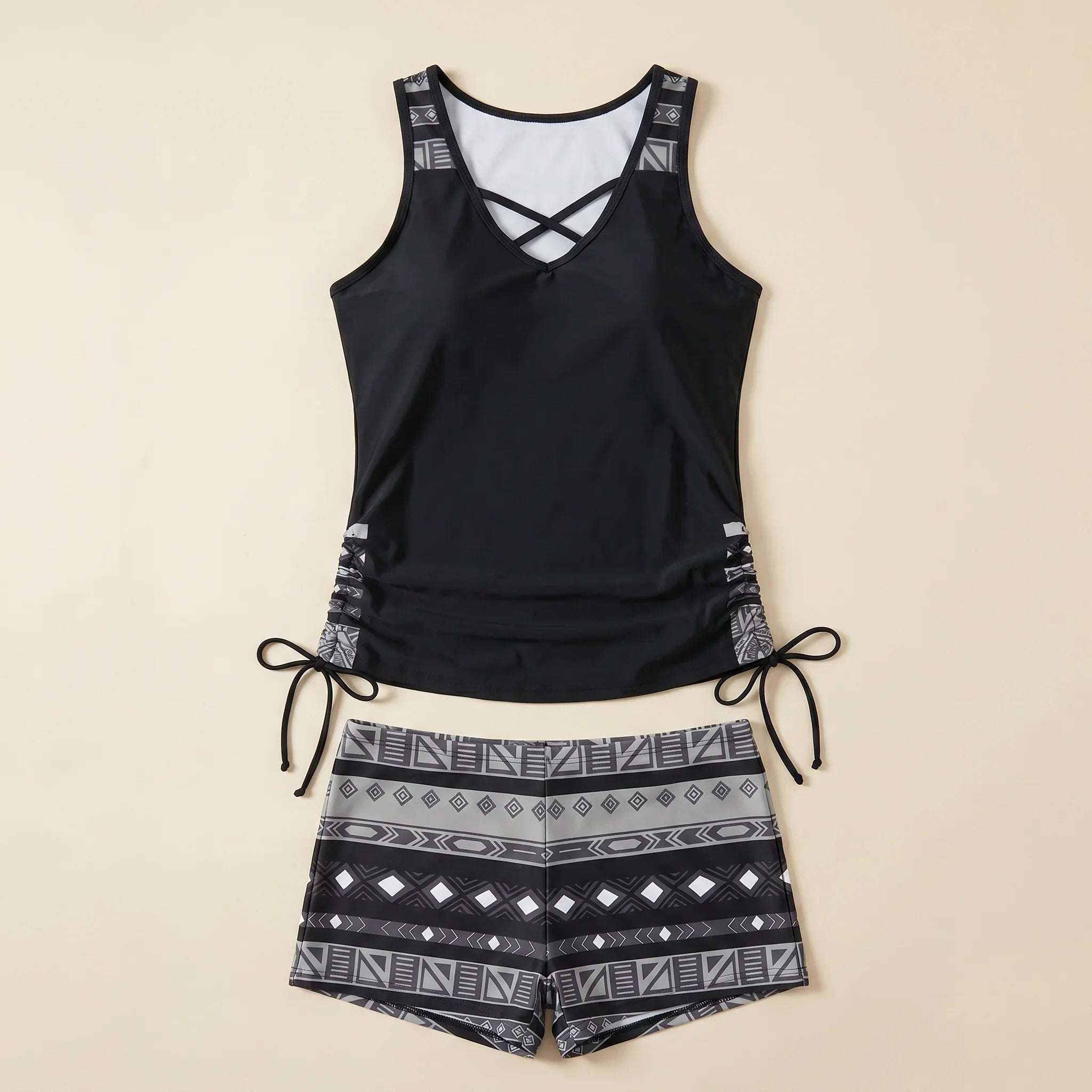 Black tankini set with crisscross neckline and geometric print swim shorts