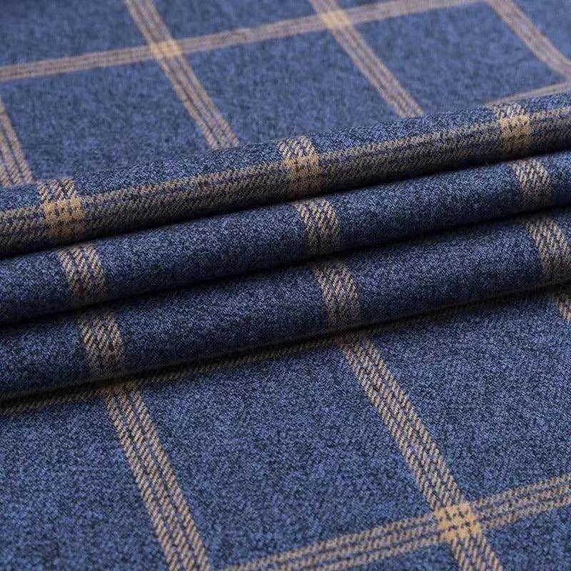 Folded navy checkered dress shirt fabric showing tan grid pattern.