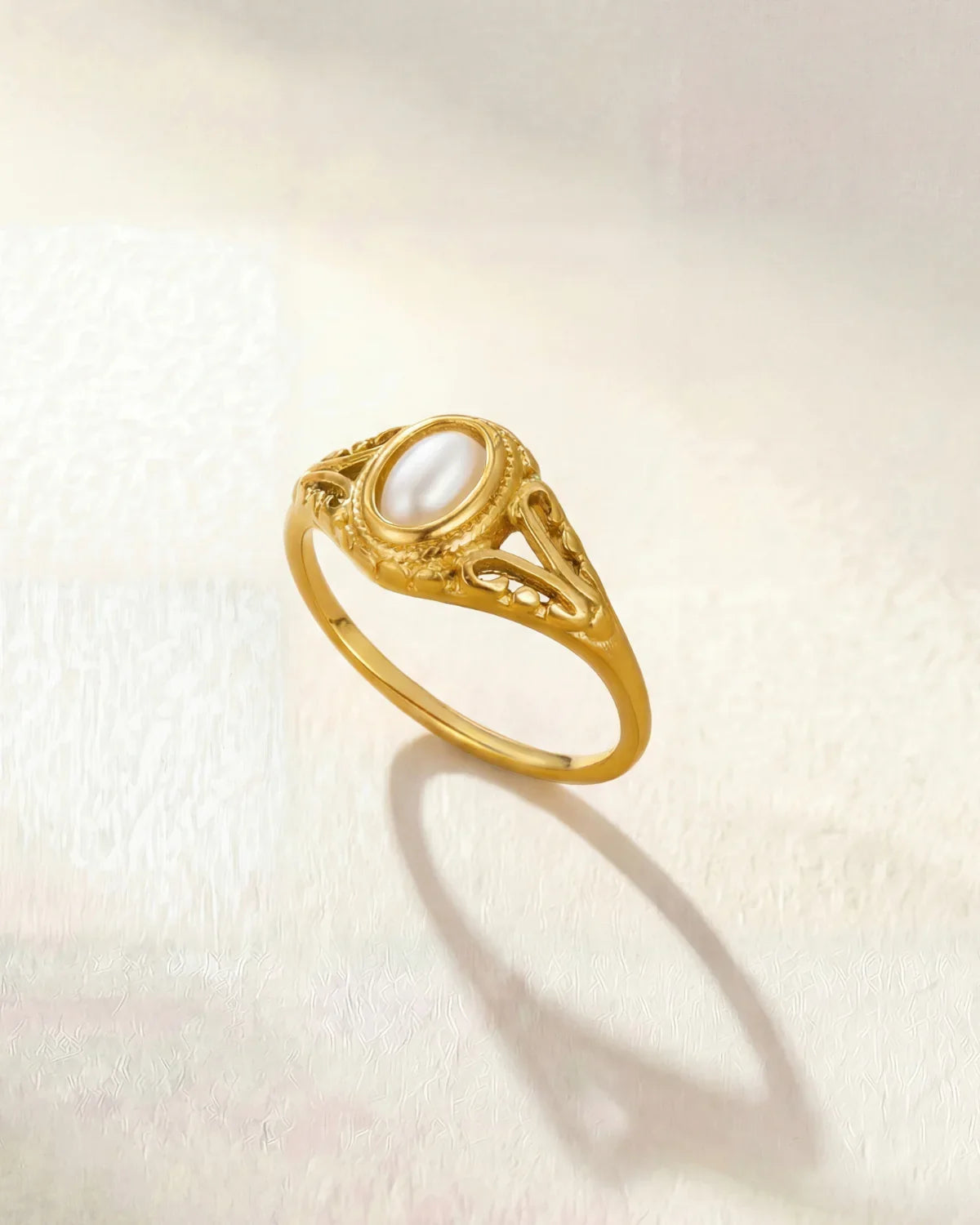 Gold oval-pearl ring with ornate filigree setting