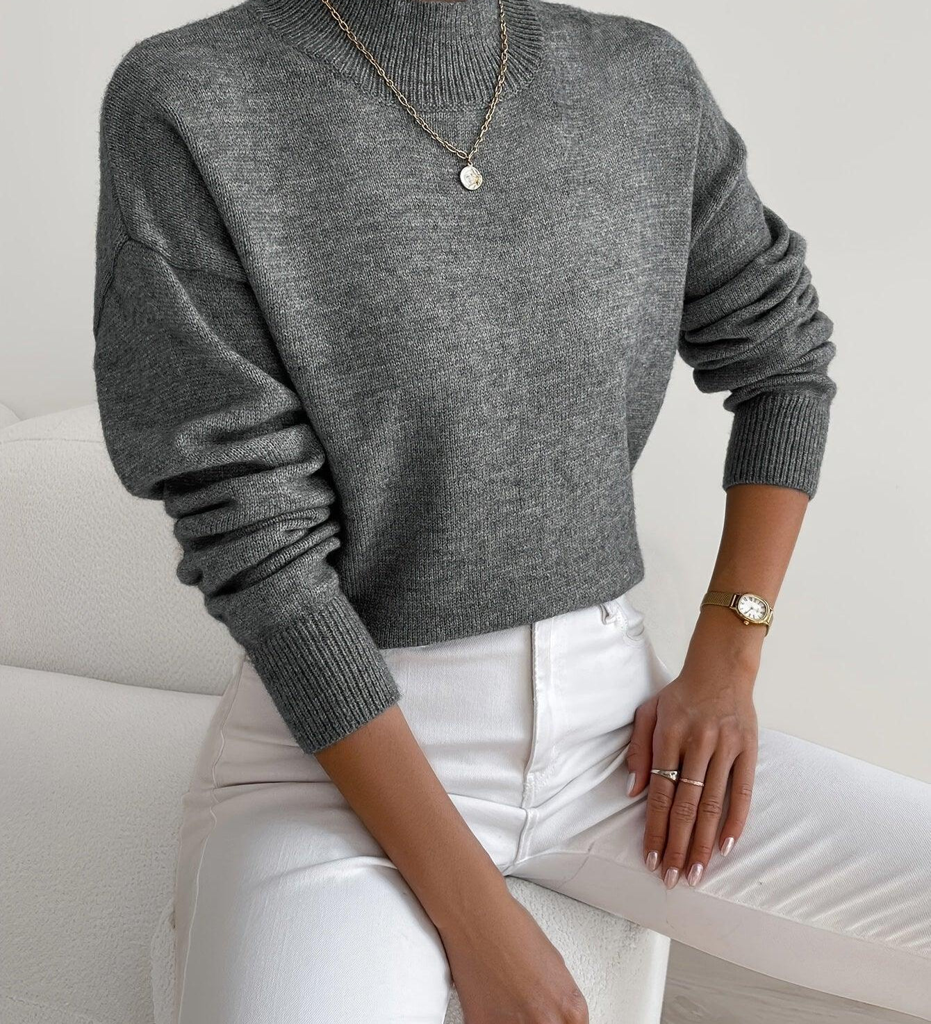 Gray knit crewneck sweater with long sleeves and ribbed cuffs and hem