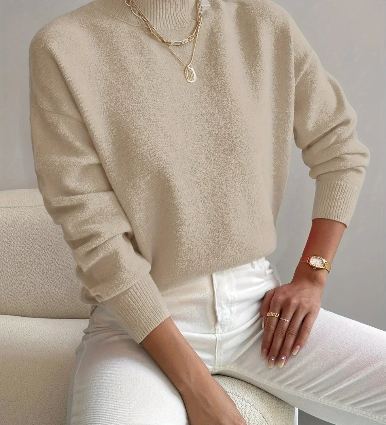 Beige knit crewneck sweater with long sleeves and ribbed cuffs and hem
