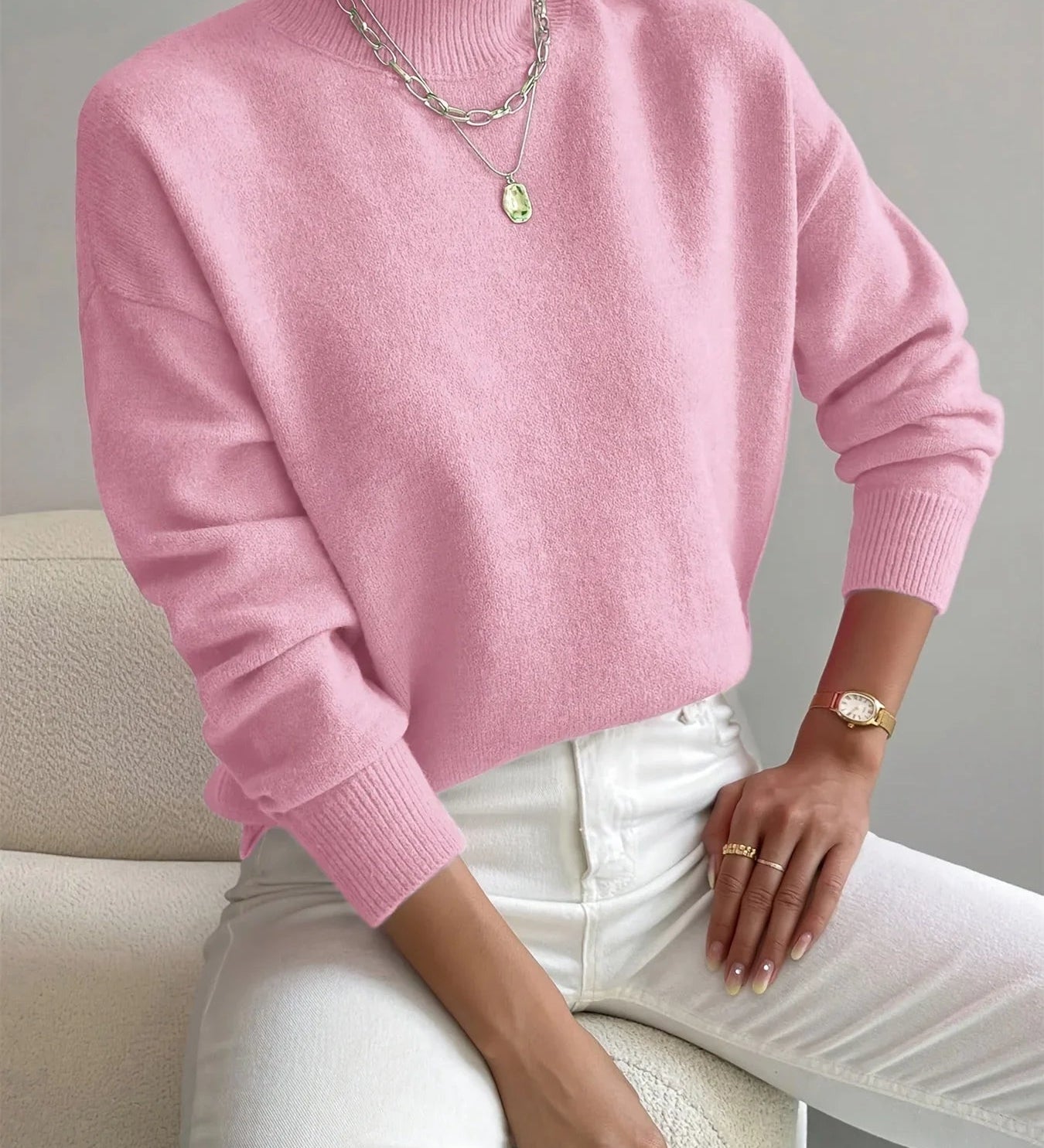 Pink knit crewneck sweater with long sleeves and ribbed cuffs and hem
