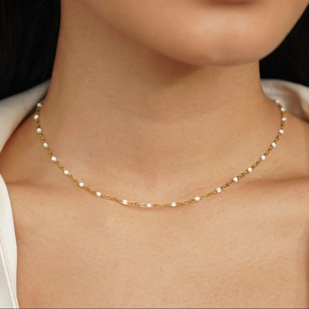Gold pearl beaded necklace with small round white beads, worn close to neck
