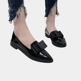 Black loafers with black buckle strap, worn with jeans