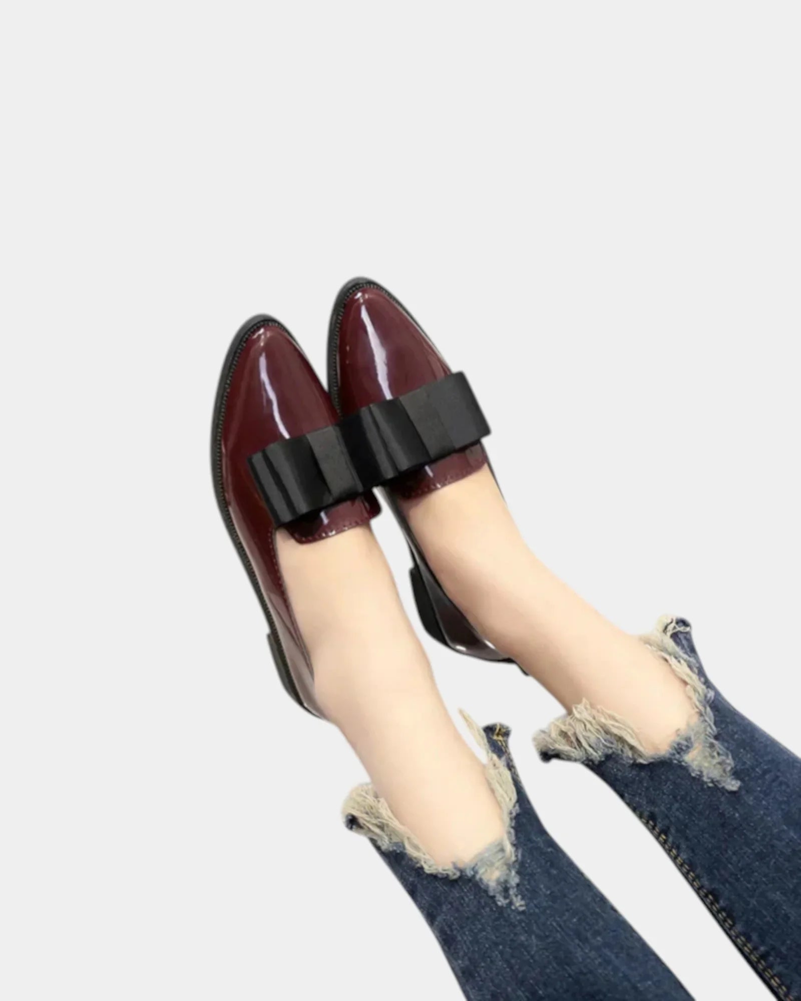 Burgundy loafers with black buckle strap, worn with denim