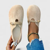 Beige suede loafers with rope-tie vamp and decorative flower brooch