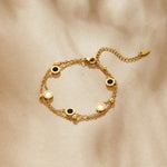 Gold chain bracelet with round black and white stone charms across the band