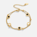 Gold chain bracelet with black and white round stone charms and lobster clasp