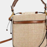 Beige-and-brown knitted bucket bag with top drawstring and leather strap detail