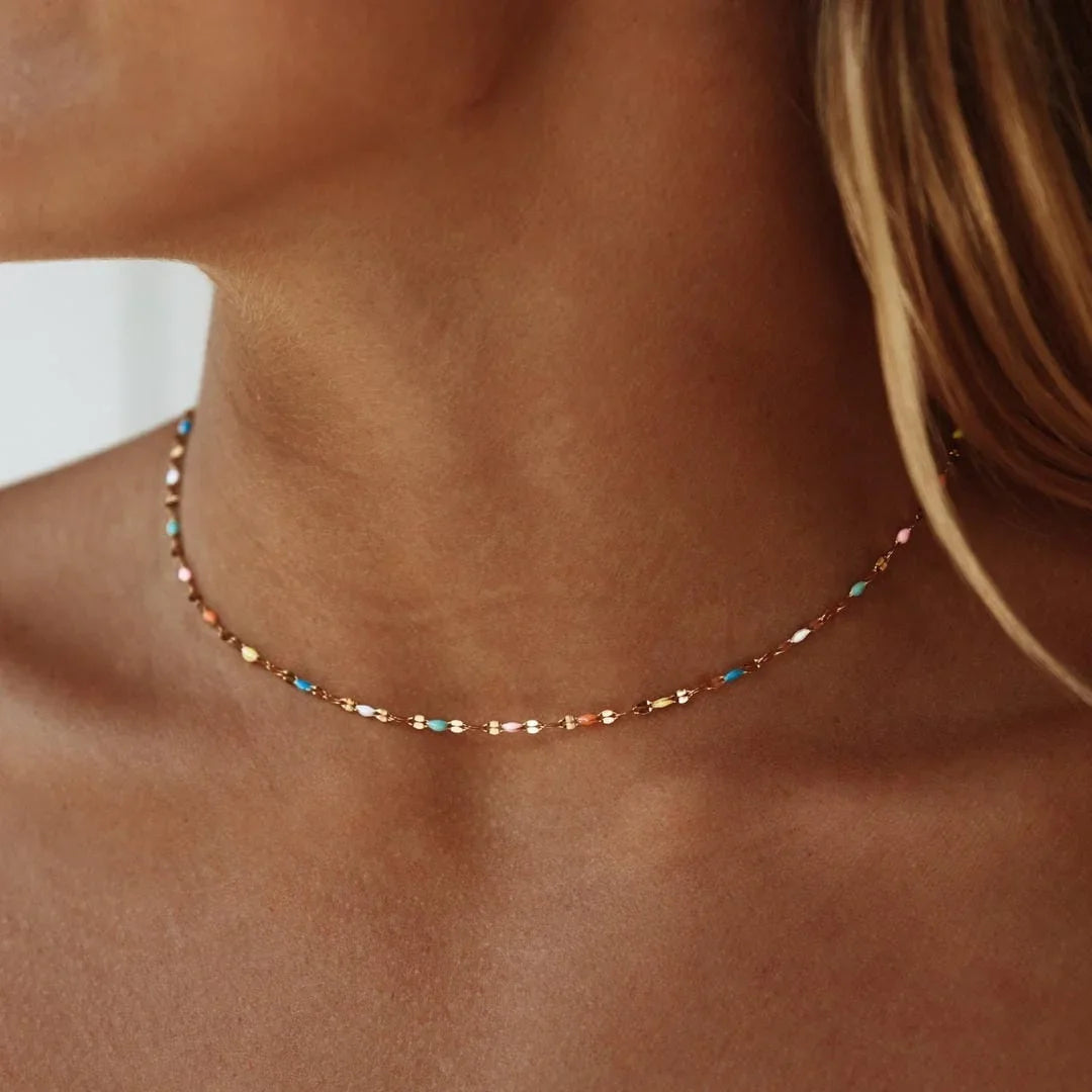 Gold-tone delicate choker necklace with small multicolor stones along the chain