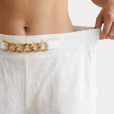 White pants waistband with gold chain trim and gathered elastic