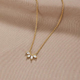 Gold-tone chain necklace with sparkling leaf-shaped crystal pendant cluster