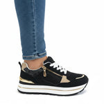 Black women’s comfort sneakers with white laces, gold-tone zipper, and thick sole