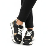Black women’s comfort sneakers with white laces and gold-tone zipper detail