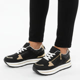 Black women’s comfort sneakers with beige accents, white laces, and zip closure
