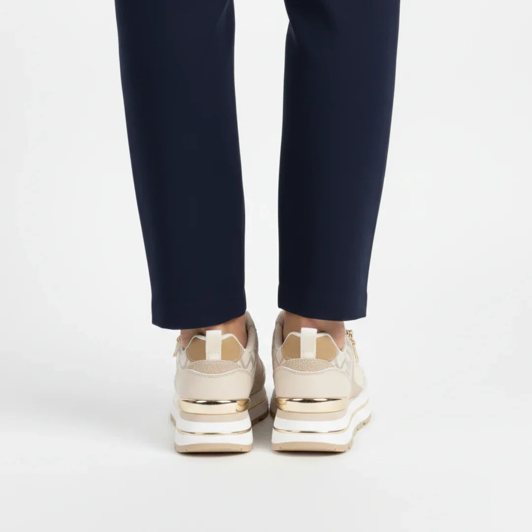 Beige women’s comfort sneakers, view from back with gold accents and thick sole