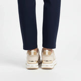 Beige women’s comfort sneakers, view from back with gold accents and thick sole
