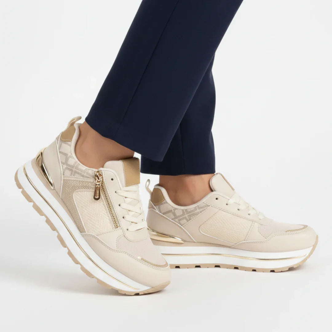 Beige women’s comfort sneakers with zip detail, white laces, and cushioned sole