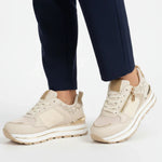 Beige women’s lace-up comfort sneakers with gold-tone zipper and sporty tread sole