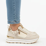 Beige women’s comfort sneakers featuring a front zip detail and cushioned low profile