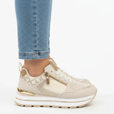 Beige women’s comfort sneakers featuring a front zip detail and cushioned low profile
