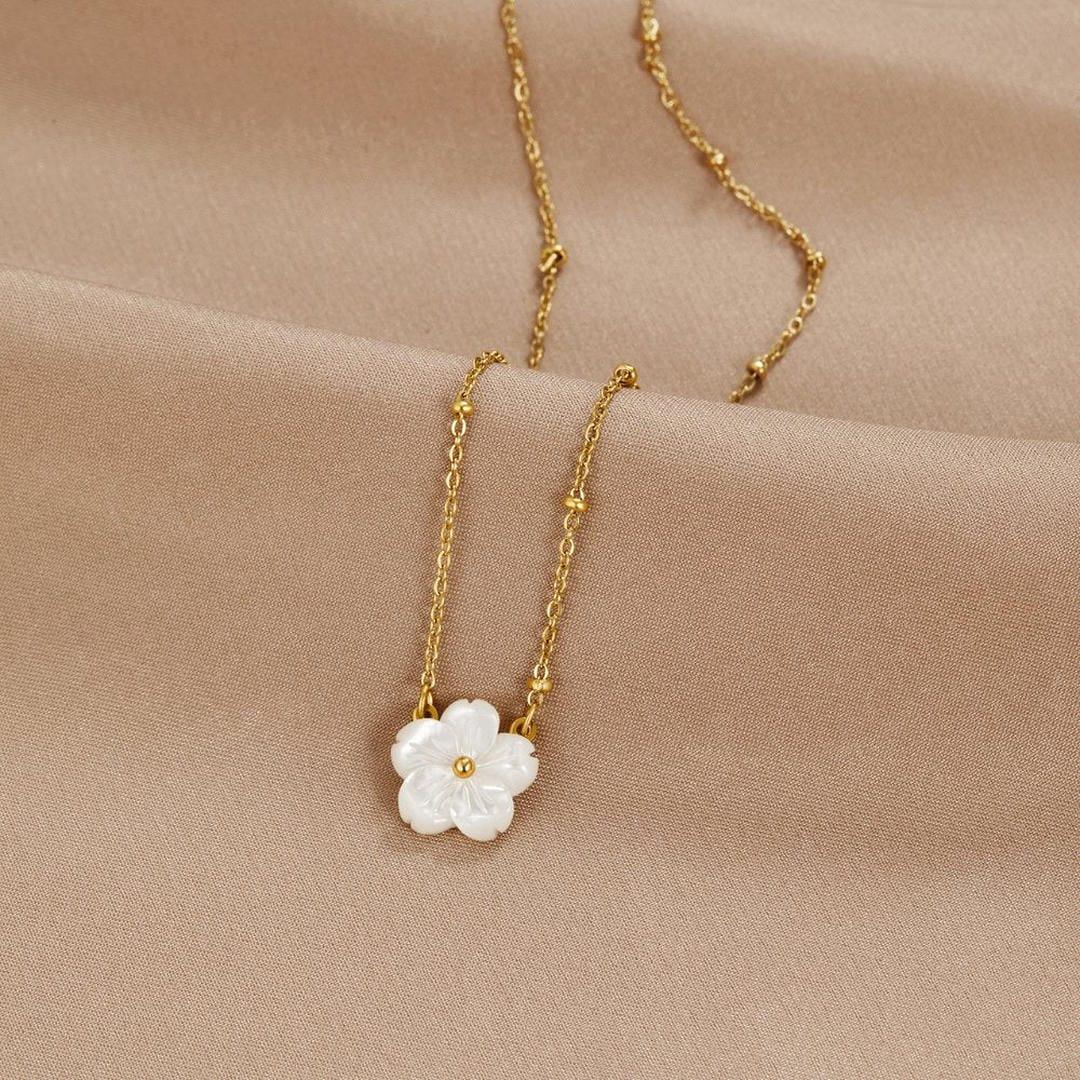Gold flower pendant necklace with white three-petal bloom on fine chain