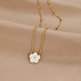 Gold flower pendant necklace with white three-petal bloom on fine chain